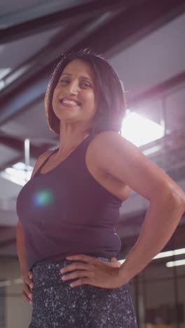 Vertical-Video-Portrait-Of-Smiling-Mature-Woman-Wearing-Fitness-Clothing-Standing-In-Gym-Ready-To-Exercise-3